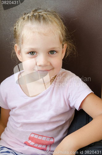 Image of Happy girl sitting on a chair in an electric train, close-up