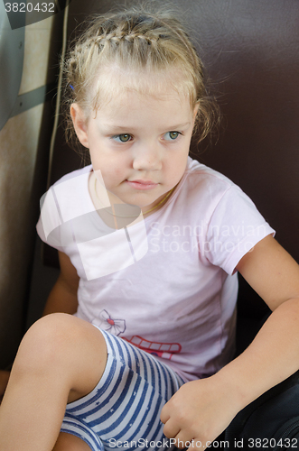 Image of Sad girl sitting on a chair in an electric train
