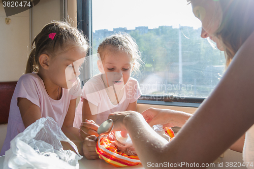 Image of My mother unpacks the food for hungry children in second-class train carriage