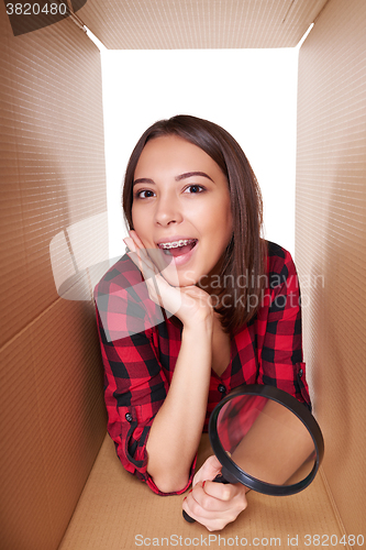 Image of Girl opening a carton box and looking inside