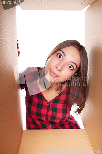 Image of Girl opening a carton box and looking inside