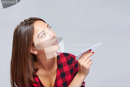 Image of Dreamy female holding white paper plane