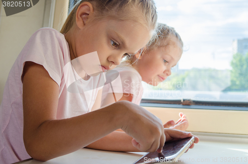 Image of Girl playing in a mobile phone in a train