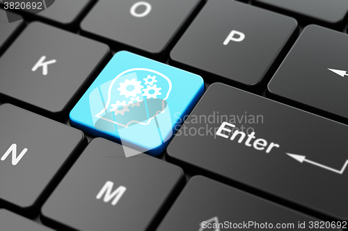 Image of Advertising concept: Head With Gears on computer keyboard background