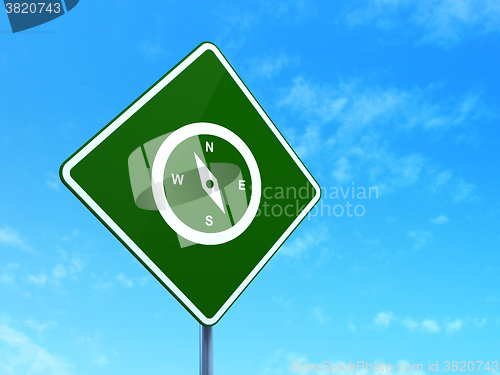 Image of Travel concept: Compass on road sign background