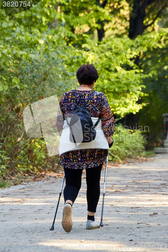 Image of Middle-aged woman walking in park