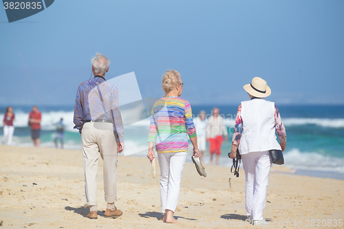 Image of Active seniors enjoying beach walk.