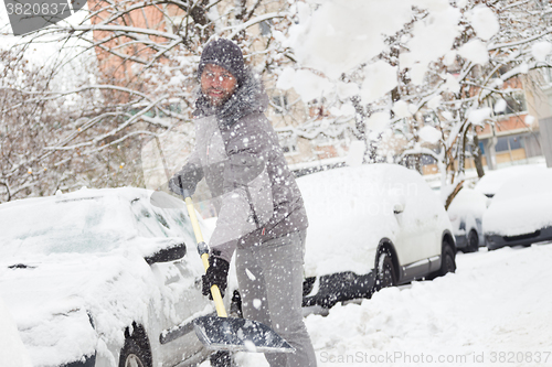 Image of Man shoveling snow in winter.