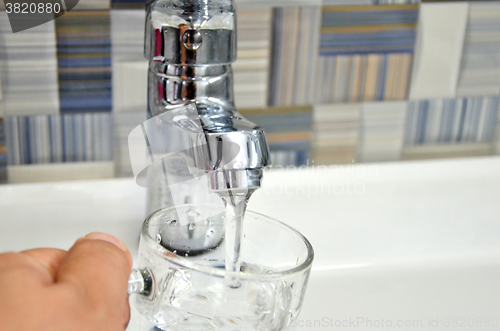 Image of Filling glass of water from  kitchen faucet