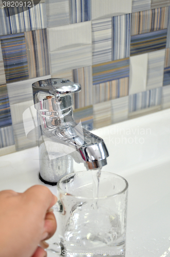 Image of Filling glass of water from  kitchen faucet