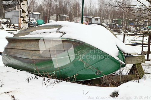 Image of  old rowing boat under the snow