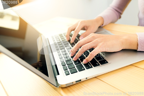 Image of Woman typing on notebook computer