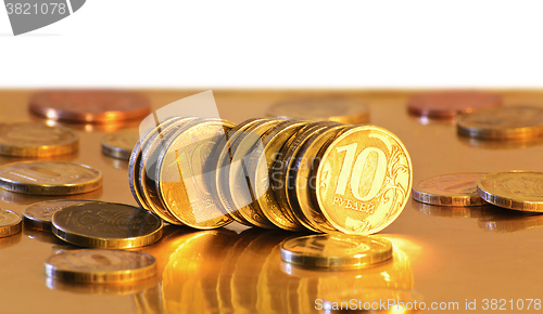 Image of Stack of coins close-up on a gold background