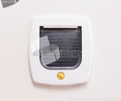 Image of Inside view of a regular white cat flap, cat comming through