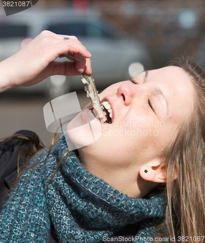 Image of Dutch woman is eating typical raw herring