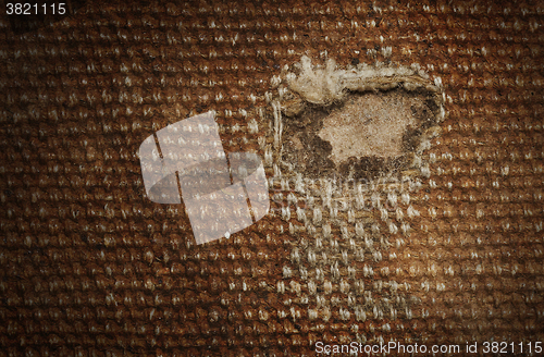 Image of Detail (damage) of an old canvas suitcase, close-up