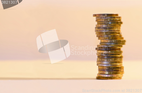 Image of Stack of coins close-up on a gold background