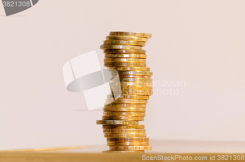 Image of Stack of coins close-up on a gold background