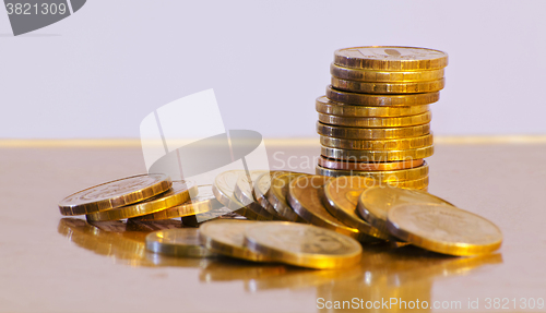 Image of Stack of coins close-up on a gold background