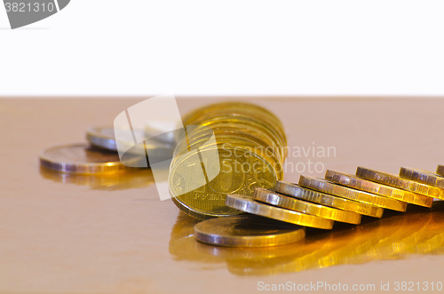 Image of Stack of coins close-up on a gold background