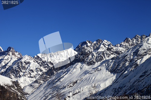 Image of View on snowy rocks and blue clear sky at nice sun day