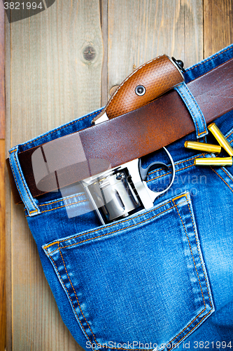 Image of old silver revolver and vintage blue jeans