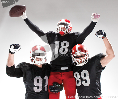 Image of The three american football players posing on white background