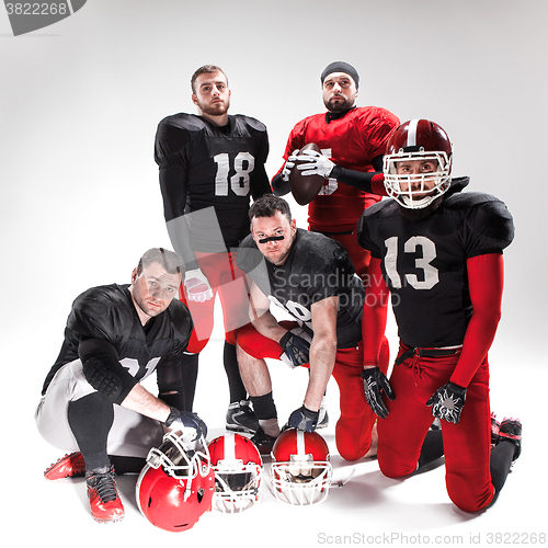 Image of The five american football players posing with ball on white background