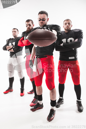 Image of The four american football players posing with ball on white background