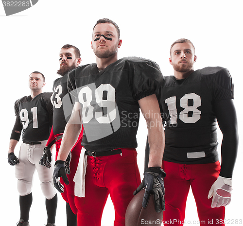 Image of The four american football players posing with ball on white background