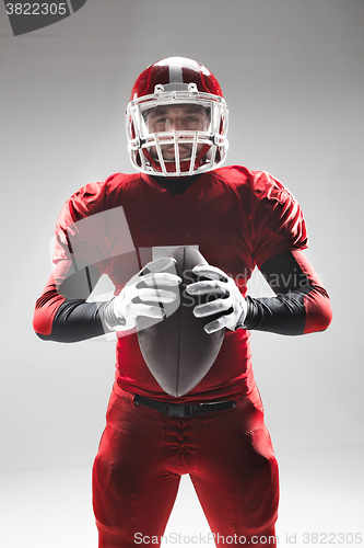 Image of American football player posing with ball on white background