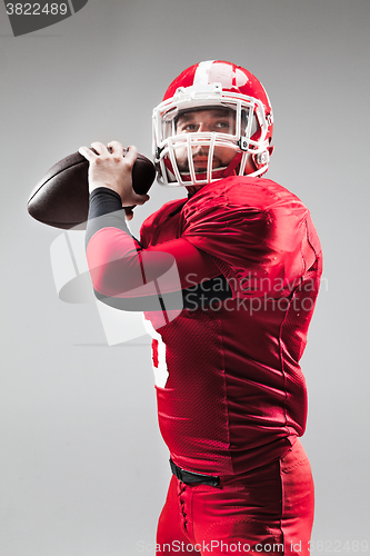 Image of American football player posing with ball on white background