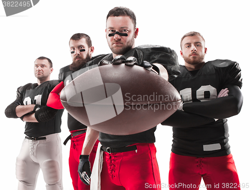 Image of The four american football players posing with ball on white background