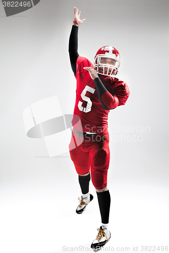 Image of American football player posing with ball on white background