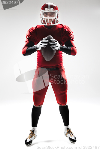 Image of American football player posing with ball on white background