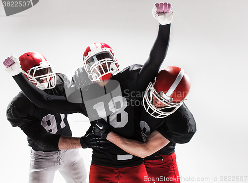 Image of The three american football players posing on white background