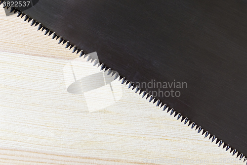 Image of Hacksaw blade and wood plank texture