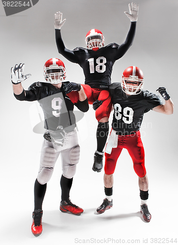 Image of The three american football players posing on white background