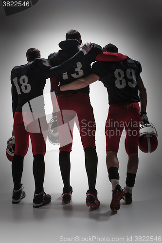 Image of The three american football players on gray background