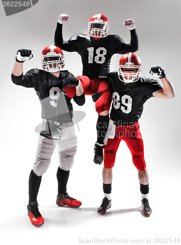 Image of The three american football players posing on white background