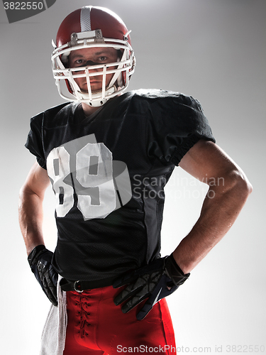 Image of American football player posing with ball on white background