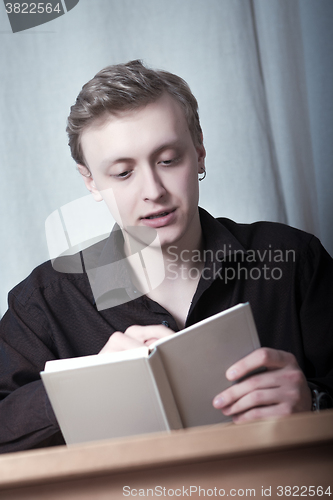 Image of Young man reading a book