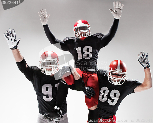 Image of The three american football players posing on white background