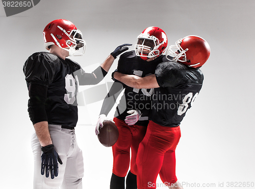 Image of The three american football players posing on white background