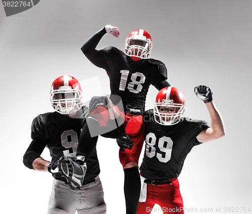 Image of The three american football players posing on white background