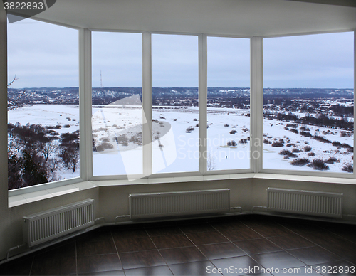 Image of wide window of verandah with winter landscape