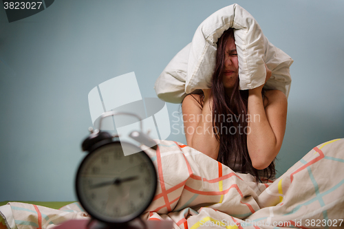 Image of Woman with a pillow over head.