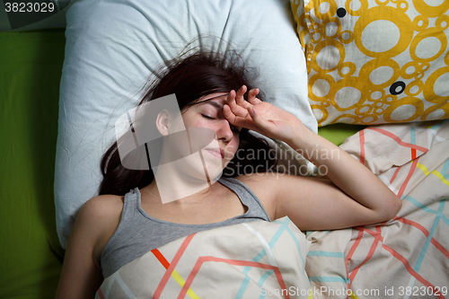 Image of Tired woman sleeping on a bed at home