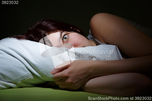 Image of Young woman in bed  eyes opened suffering insomnia. Nightmare issues