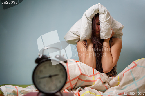 Image of Woman with a pillow over head.